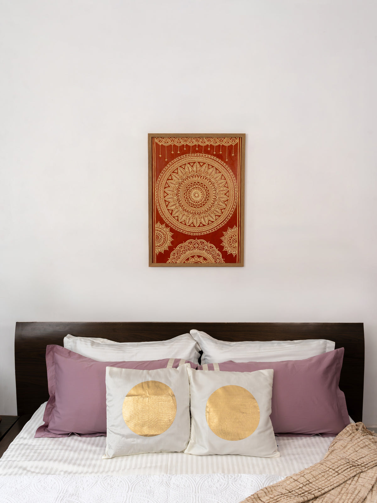 Hand-built mud relief mandala against a deep terracotta ground